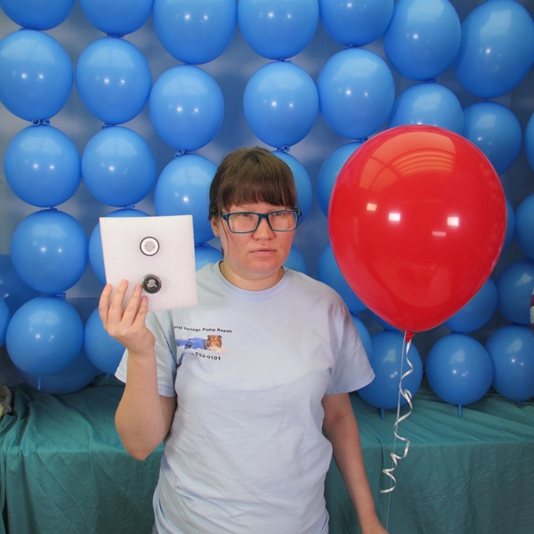 pretty girl with blue glasses and red balloon holding pump seal